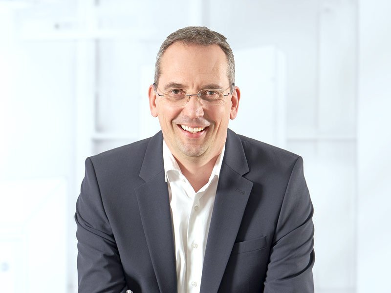 Herr Müller mit einem Stift in der Hand.